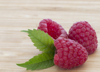 Ripe sweet raspberries on wooden table