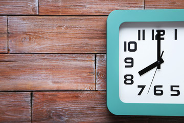 Green clock on a brown wooden table