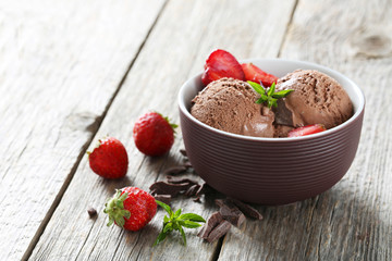 Sweet ice cream in bowl on grey wooden background