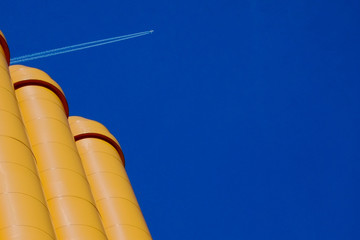 yellow pipe with plane in blue sky
