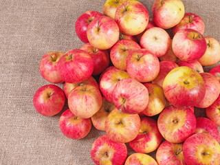 Lying red fresh apples on a fabric background.