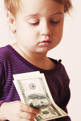 Baby girl counting money. Dollars. success, wealth management. (