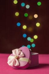 Pink gift box open shaped heart with Defocused bokeh colorful li