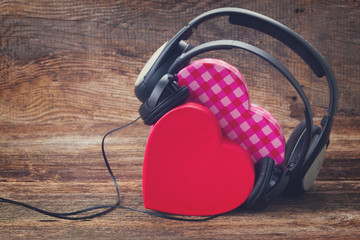 Romantic music concept - two pink and red hearts with headphones, retro toned