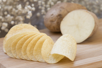 Fototapeta na wymiar Potato chips on wooden block.