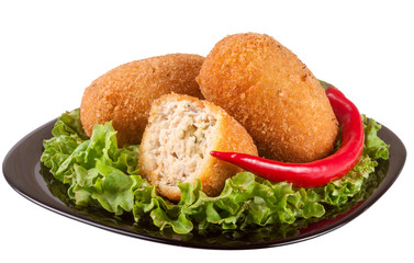 three fried breaded cutlet with lettuce on a black plate isolated white background