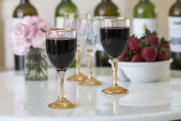 Red wine in a glasses on white table background.