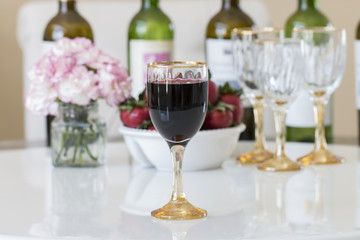 Red wine in a glasses on white table background.