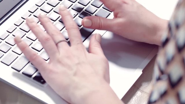 Girl's hands working on the keyboard of a laptop computer