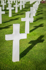 White crosses on graveyard with shadow