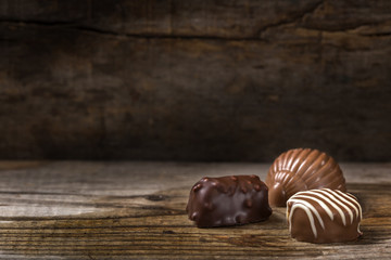 Three different types of chocolate candy over rustic wood
