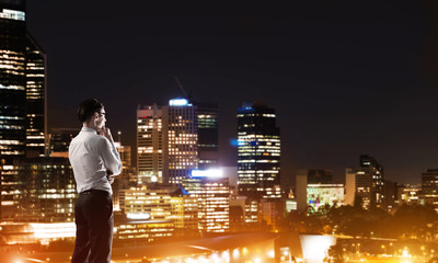 Businessman viewing night glowing city