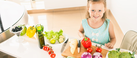 Cute little girl making salad. Child cooking. Healthy food