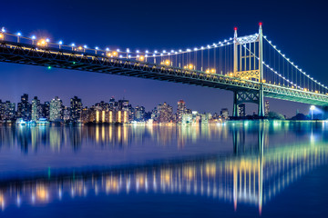 Obraz premium Beautiful night view with lights of Robert F. Kennedy RFK bridge formerly known as the Triborough bridge from Astoria Queens across the East River toward New York City upper Manhattan skyline