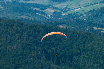 View of a paraglider above the mountain valley. Paragliding.