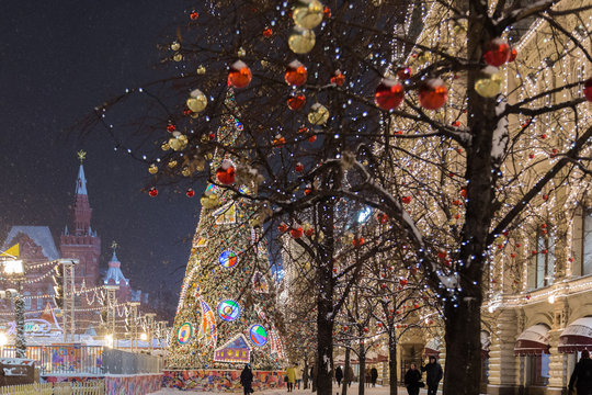 Russia, Moscow, Red Square, GUM Shopping Center on winter, snowing evening with a decorated tree in front.