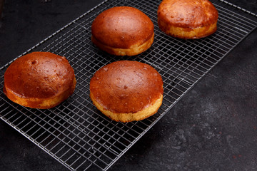 Tasty fresh newly-baked buns on a iron grid over stone background