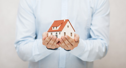 Small toy house in hands