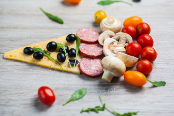 Creative composition of ingredients tomatoes, cheese, salami, mushrooms, arugula, olives in the form of a slice of pizza