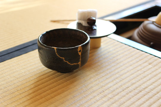 金継ぎの黒い楽茶碗と茶釜がある日本の茶室風景（人物なし）