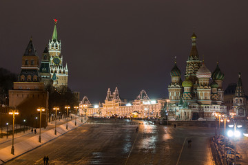 Russia, Moscow. View on a Red Square from the Moskvaretsky bridge, St. Basil Cathedral on the right, Kremlin on the left, State Department Store is on the center. Evening, snow, winter.