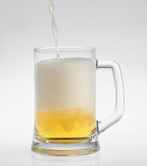 Glass of light beer on white background