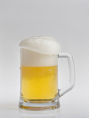 Glass of light beer on white background