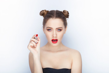 Young pretty woman trendy makeup bright red lips bun hairstyle bare shoulders act the ape with lipstick white studio background