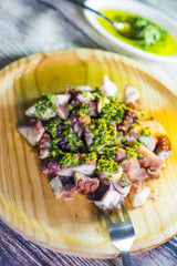 Octopus with paprika and sauce on a wooden table