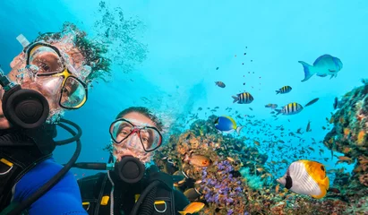 Foto auf Acrylglas Taucher, die unter Wasser in die Kamera schauen © Jag_cz