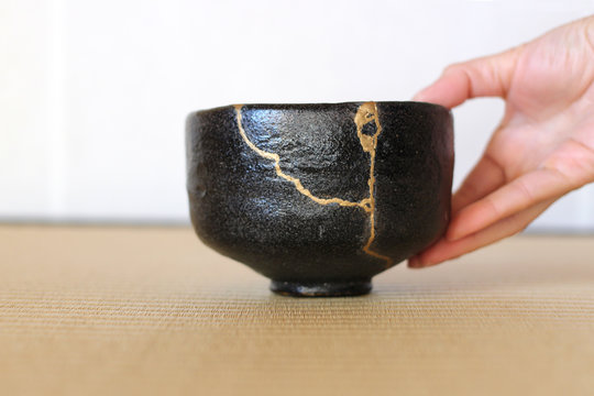金継ぎの黒い楽茶碗を右手で畳の上に置く茶道の所作