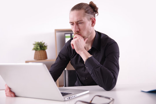Gesch&auml;ftsmann blickt in seinen Laptop
