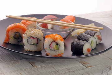 close up of sashimi sushi set with chopsticks and soy - sushi roll with salmon and sushi roll with smoked eel, selective focus.