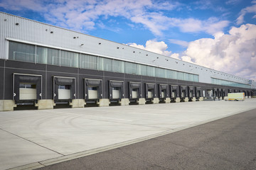 dock cargo doors at big warehouse - obrazy, fototapety, plakaty