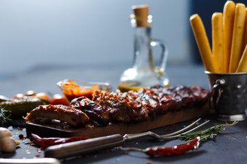 Grilled steak sliced on a cutting board. Entrecote with garlic and chilli on a dark background.