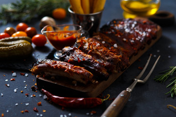 Grilled steak sliced on a cutting board. Entrecote with garlic and chilli on a dark background.