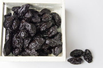 Dried plum fruits in a wooden box