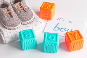 baby's bootees and gift box on wooden background