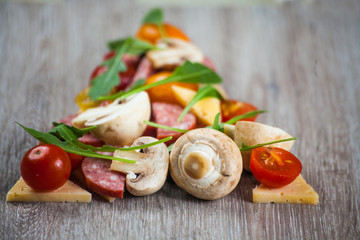 Creative composition of ingredients tomatoes, cheese, salami, mushrooms, arugula, olives in the form of a slice of pizza