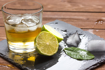 glass of whiskey on wooden background
