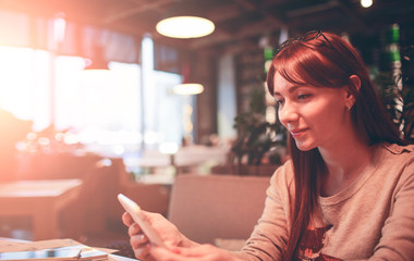 woman using a mobile phone in restaurant, cafe,bar