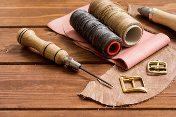 Fototapeta na wymiar leather craft instruments on wooden background close up