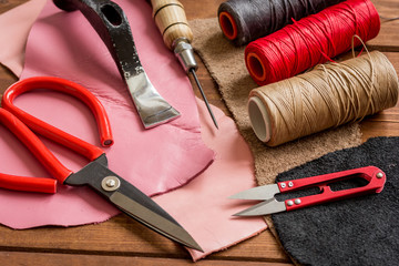 leather craft instruments on wooden background close up