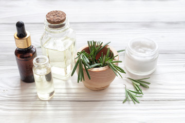 Fototapeta na wymiar organic cosmetics with extracts of herbs rosemary on wooden background