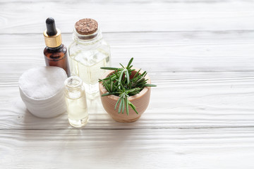 organic cosmetics with extracts of herbs rosemary on wooden background