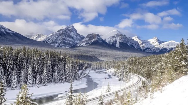 Time lapse of scenic Morant's Curve in winter Banff National Park Alberta Canada in January. Clip has a train running down the tracks.