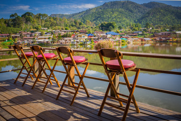 Fototapeta na wymiar Lonely empty chairs on a deck at rak Thai Village in Mae Hong So