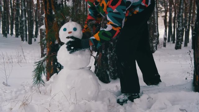 Man in the Pine Forest Sculpts Snowman