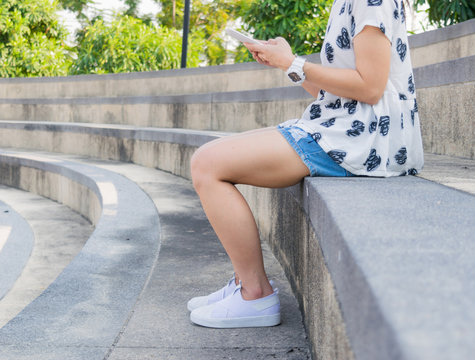 Woman legs wearing white shoes sitting sport.