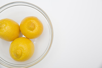 Fresh lemons in a glass bowl